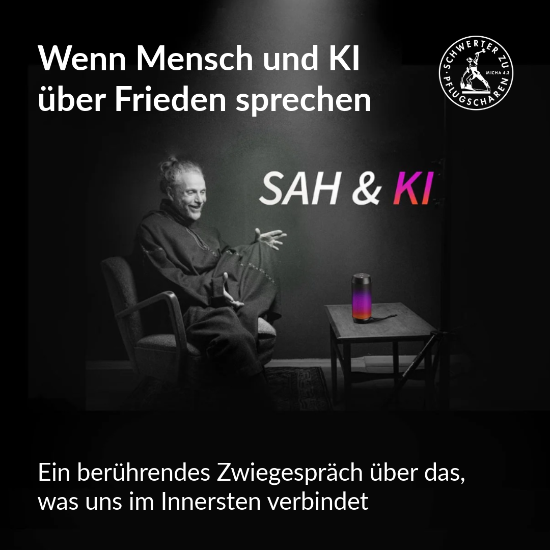 Ein Mann sitzt lachend auf einem Stuhl in einem dunklen Raum.
